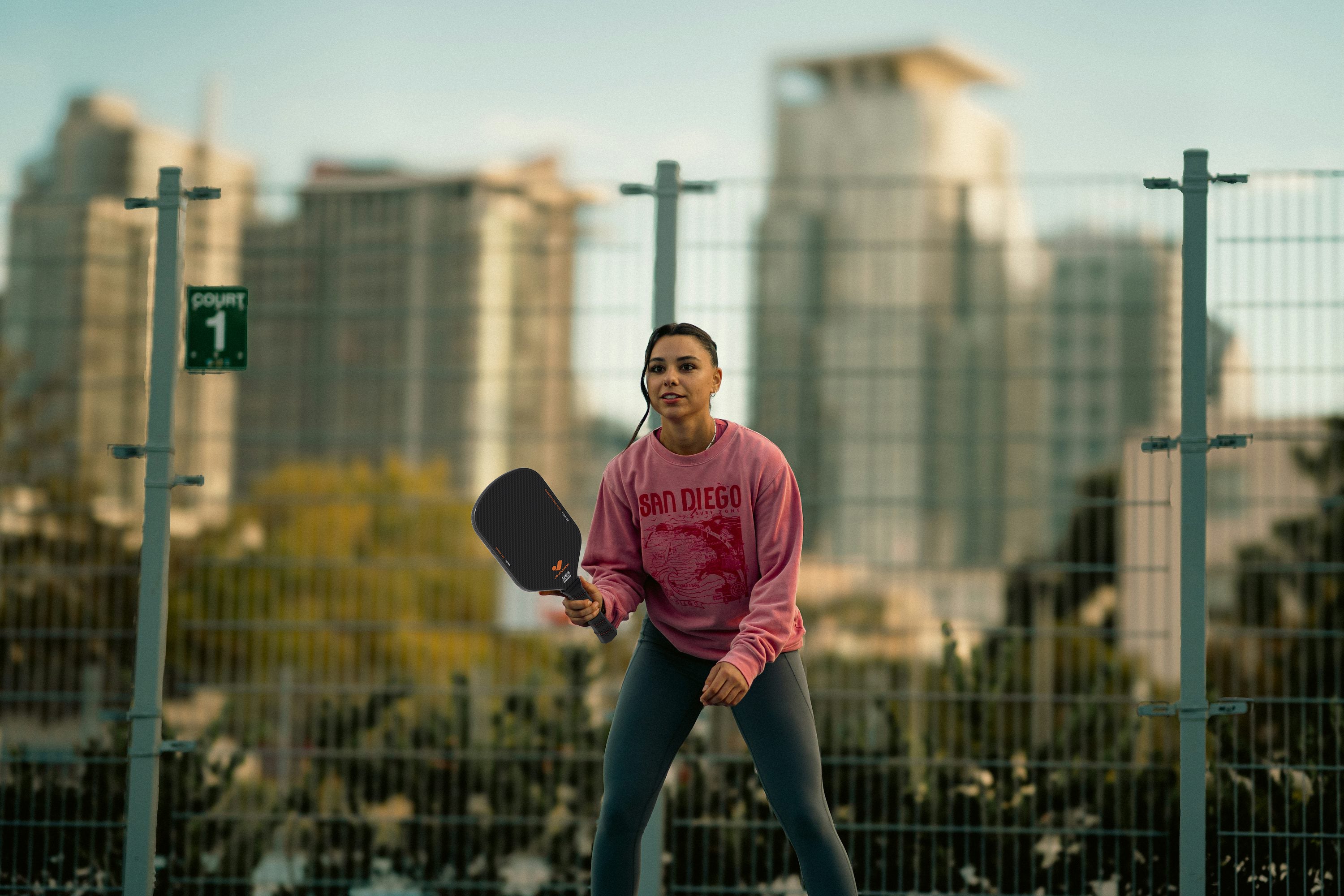 Player practicing soft dinks at the net with a carbon fiber paddle.