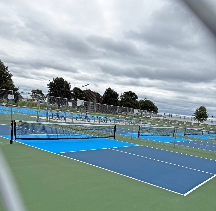 Players enjoying a game on an outdoor pickleball court with paddles and net